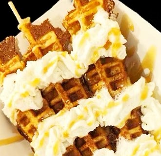 Waffles on a stick with whipped cream and caramel